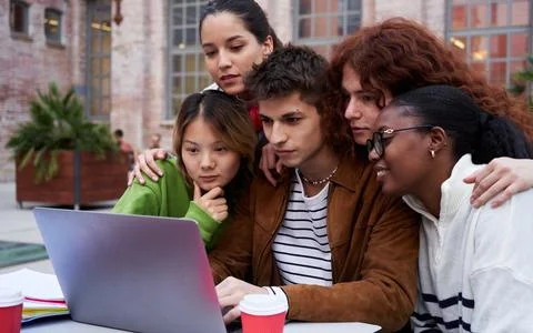 Multiracial group of students gathering to study at university campus using a Stock Photos