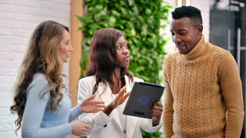Multiracial group of workers in an office discussing business affairs using a Stock Footage 235221234