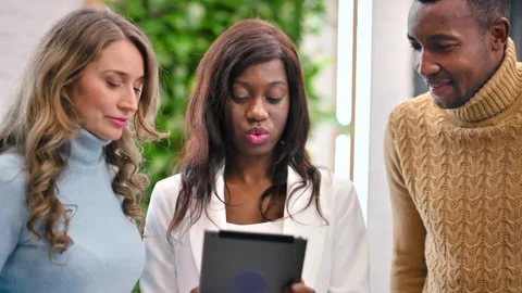 Multiracial group of workers in an office discussing business affairs using a Stock Footage 235221483