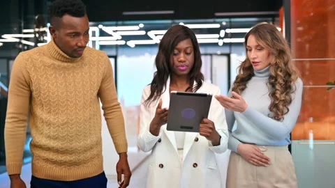 Multiracial group of workers walking in an office and discussing business Stock Footage 235218946