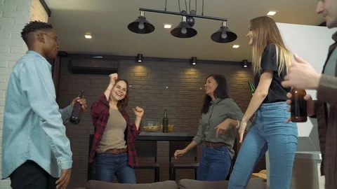 Multiracial group of young people is dancing drinking beer having fun at home Stock Footage 124042905