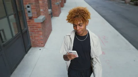 Multiracial guy teenage student using smartphone outdoor on city street while Stock Footage 217940476