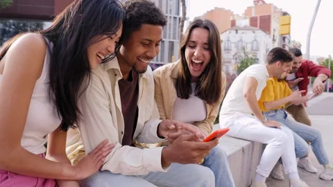 Multiracial happy group of friends using phone and smiling together outdoor Stock Footage 245744773