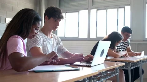Multiracial high school students doing homework using laptop.Handheld 4k video. Stock Footage 220257304