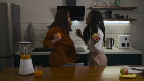 Multiracial lesbian couple dancing and having fun in the kitchen. Stock Footage 301101265