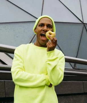 Multiracial man surprised while eating apple in urban setting Stock Photos