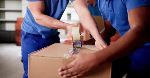 Multiracial Movers Pack Cardboard Boxes To Relocate Families Stock Photos