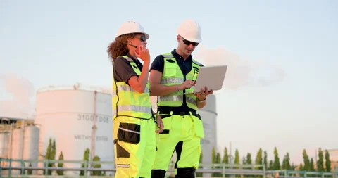Multiracial refinery engineer checking digital maintenance data on laptop while Stock Footage 335604130