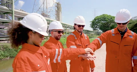 Multiracial refinery inspection team stacks hands in slow motion near pipeline Stock Footage 334832966