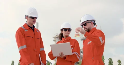 Multiracial refinery team tests liquid sample while female engineer checks Stock Footage 341479023