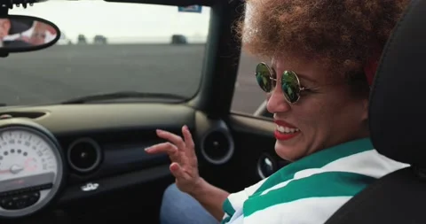 Multiracial senior couple having fun doing a road trip with convertible car Stock Footage 153403250