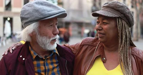 Multiracial senior couple having fun outdoor with city in background Stock Footage 174241067