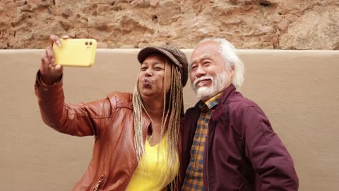 Multiracial senior couple having fun doing selfie outdoor Stock Footage 177941880