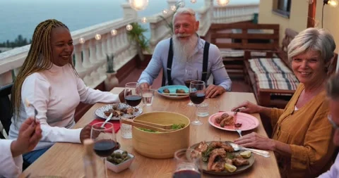 Multiracial senior friends doing dinner together at home outdoor 動画素材 141122774