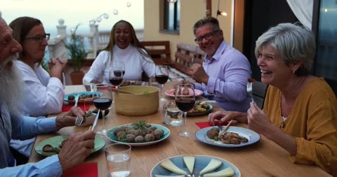Multiracial senior friends doing dinner together at home outdoor Stock Footage 141122875