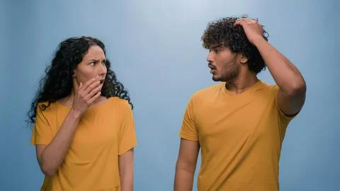 Multiracial shocked scared afraid couple amazed shocked Hispanic woman hiding Stock Photos