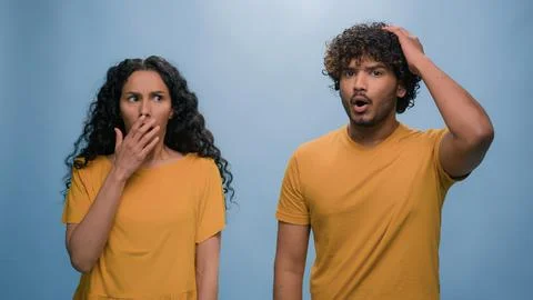 Multiracial shocked scared afraid couple amazed shocked Hispanic woman hiding Stock Photos
