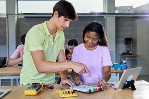 Multiracial students in electronic class learning together and helping each Stock Photos