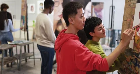 Multiracial students having fun painting inside art room class at university Stock Footage 168623658