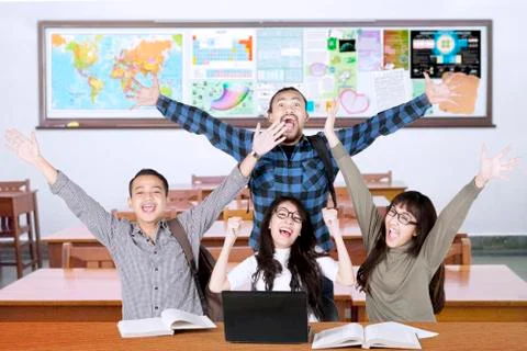 Multiracial students raise hands in class Foto stock