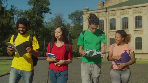 Multiracial students walking to class on campus Stock Footage