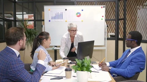 Multiracial team brainstorming financial data on briefing in modern office. Stock Footage 99044801