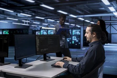 Multiracial team in data center facility running system diagnostic tests Stockfoto's