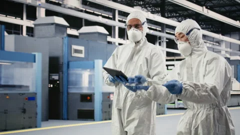 Multiracial team examining semiconductor substrate in cleanroom Stock Footage 333395529