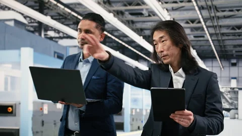 Multiracial team of microchip factory managers studying on manufacturing gear Stock Footage 333394928