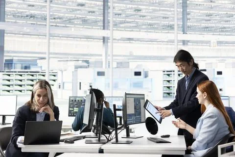 Multiracial team working together to design complex PCB layout on computer Foto stock