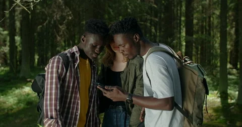 Multiracial tourists are using smartphone while trekking at hte forest, hiking Stock Footage 171688445