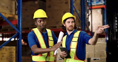 Multiracial warehouse workers coordinating inventory details while pointing and Stock Footage 315782239