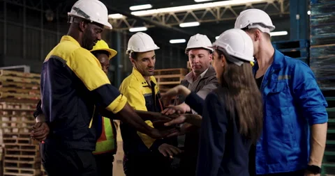 Multiracial warehouse workers stacking hands in slowmotion teamwork gesture to Video stock 324776508