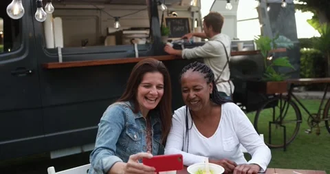 Multiracial women having fun taking photos with mobile phone 動画素材 156454244