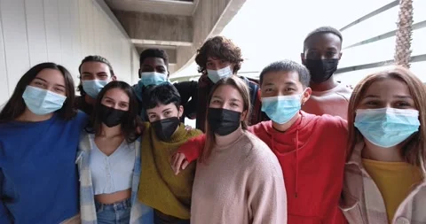 Multiracial young friends having fun outdoor while wearing safety face masks Stock Footage 168623226