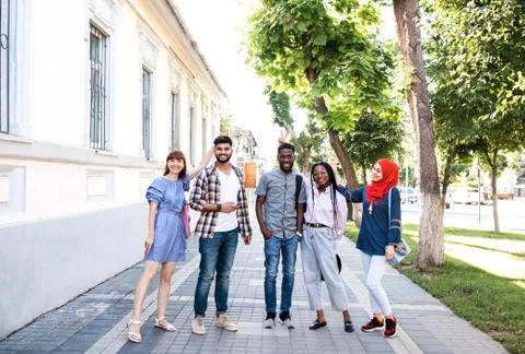 Multiracial young friends posing at the street and having fun. Stock Photos