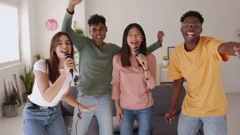 Multiracial young people having fun playing karaoke at home party Stock Footage 220234517