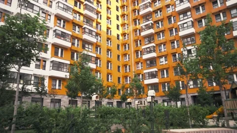 Multistory residential development with a bright façade and multiple vegetation Stock Footage 223129514