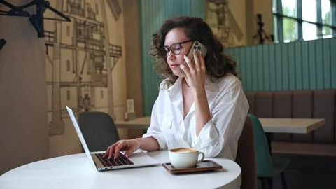 Multitasking concept. Woman using laptop, drink coffee, talking smartphone Stock Footage 302155815