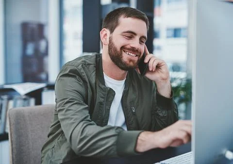 Multitasking is easy for him. a young designer talking on a cellphone while Stock Photos