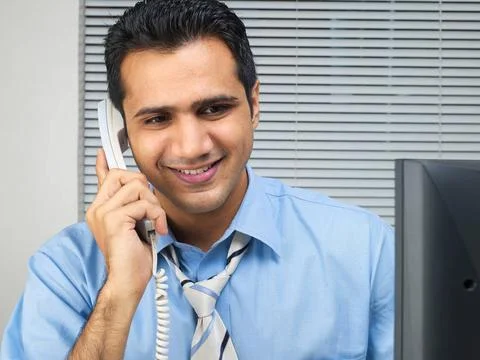 Multitasking executive talking on phone looking at computer MR 779K Copyri... Stock Photos