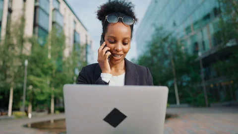 Multitasking freelancer woman talking by mobile phone and working with laptop. Video stock 346056102