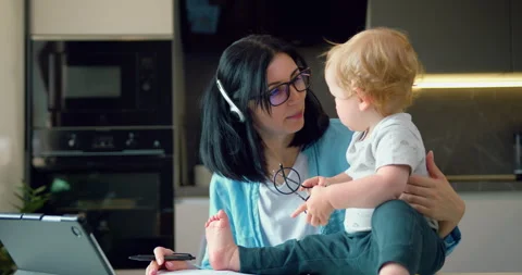 Multitasking mom With Little Child working remote is stressed out, using laptop Stock Footage 243834726