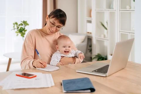 Multitasking mom working from home while spending time with her baby Foto stock