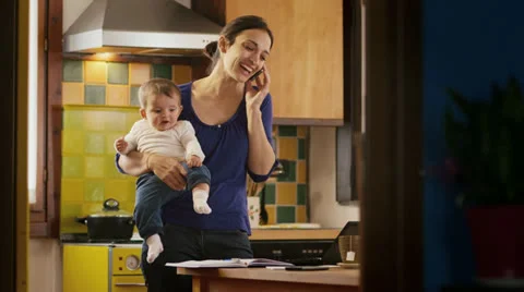 Multitasking mother working with computer, holding little girl at home Stock Footage 24307710