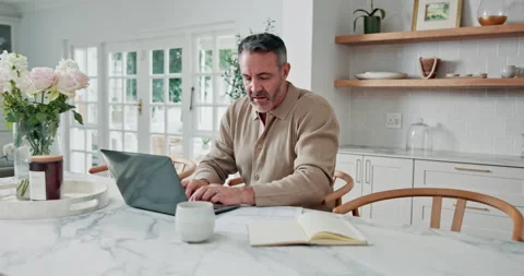 Multitasking, paperwork and man with laptop in kitchen, remote work and Stock Footage 337759325