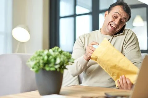 Multitasking. Portrait of hispanic middle aged business man talking on the phone Stock Photos