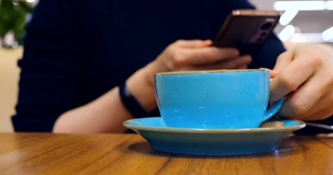 Multitasking professional relaxing during break, sipping coffee while scrolling Stock Footage 314468239