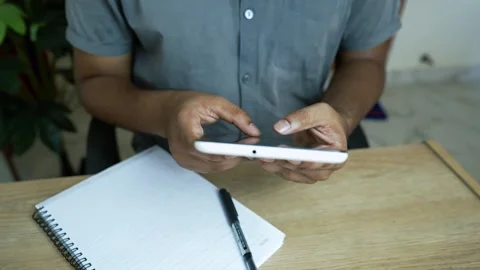 Multitasking with Smartphone and Notepad, Person using a smartphone and tak.. Stock Footage 317737230