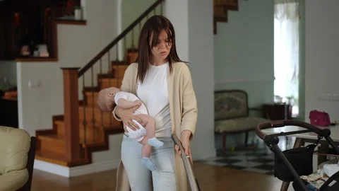 Multitasking super mom vacuuming while holding her sleeping baby Stock-Footage 331304506